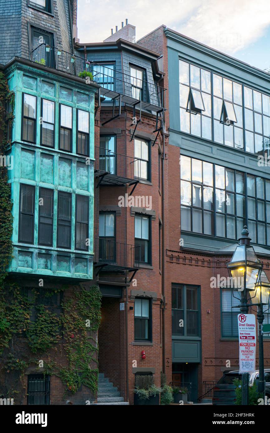 Historic brownstone houses with big windows and copper teal wall in