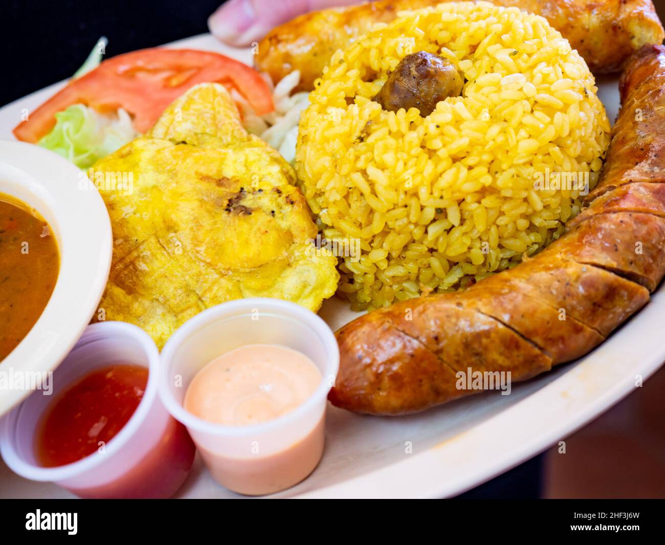 A classic dish of longaniza, rice and beans, tostones Stock Photo