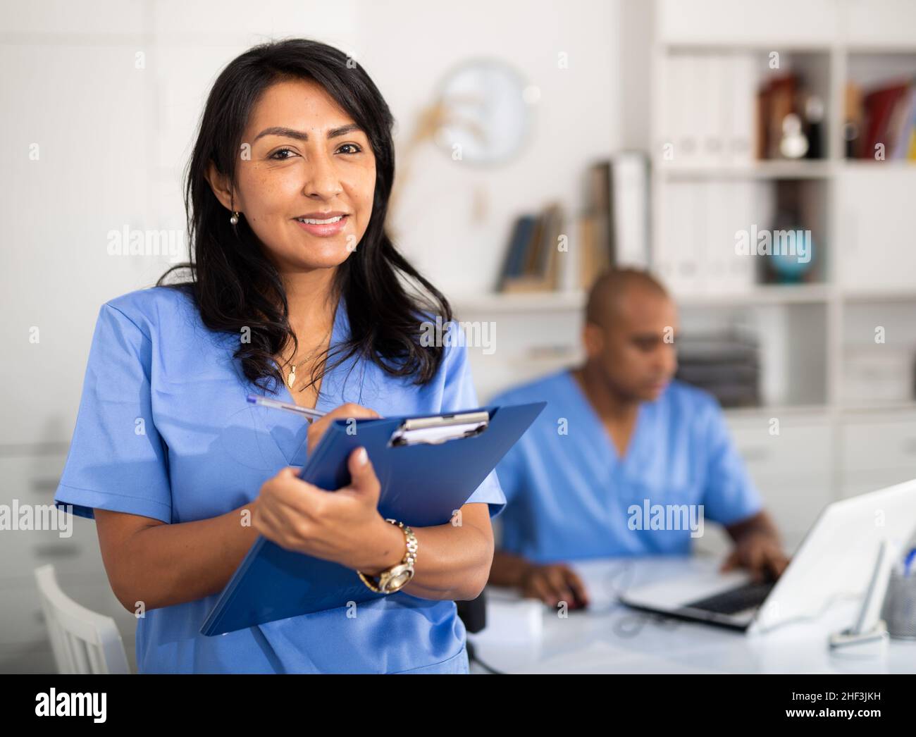 Female health worker filling out medical form in office Stock Photo Alamy