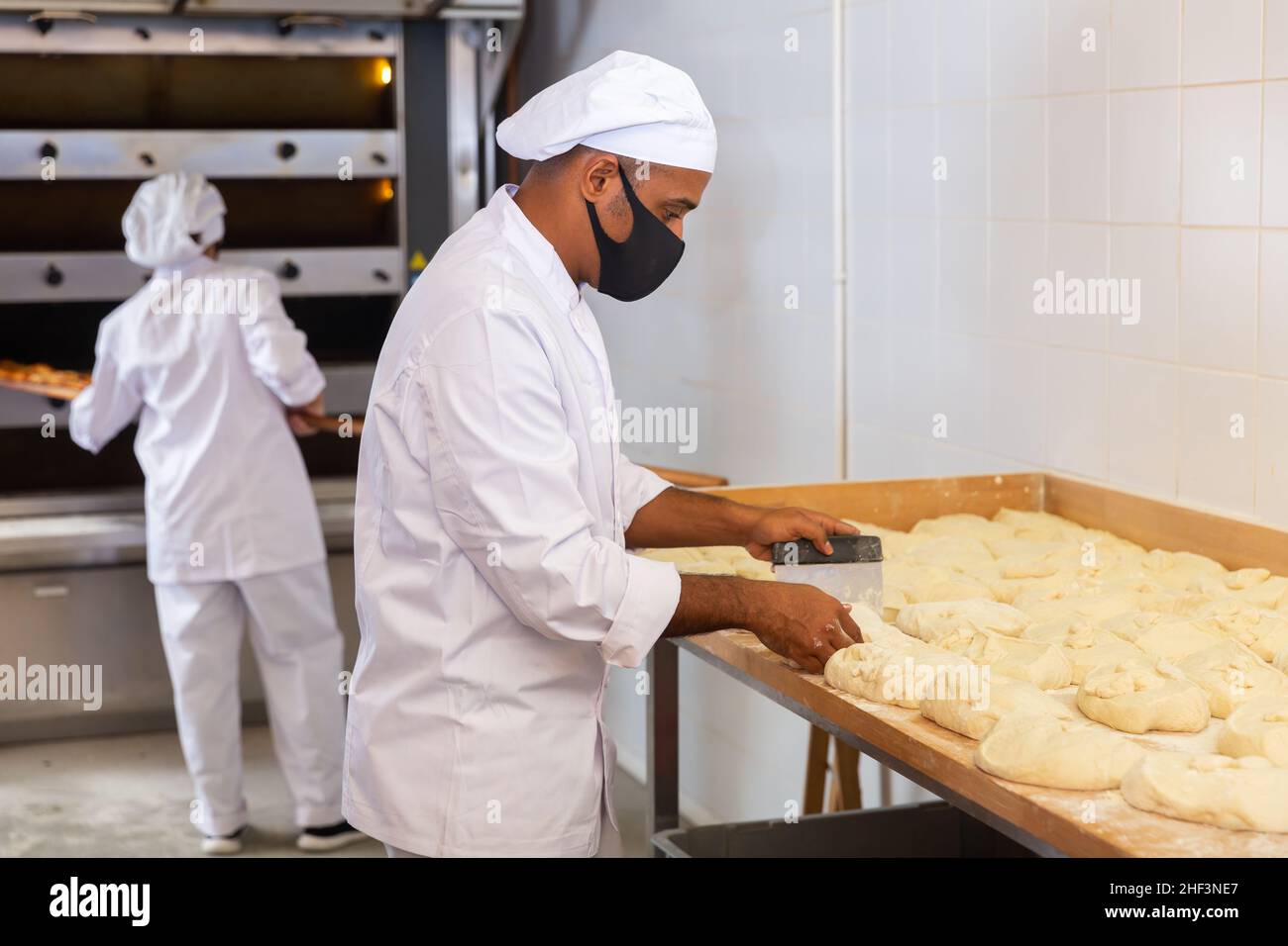 baker weighing bread dough on scale at bakery Stock Photo - Alamy