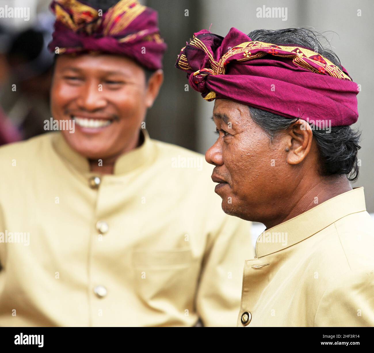Two Balinese men wearing udeng headwear at a ceremony taking place in the village of Ketewel in Gianyar, Bali, Indonesia Stock Photo