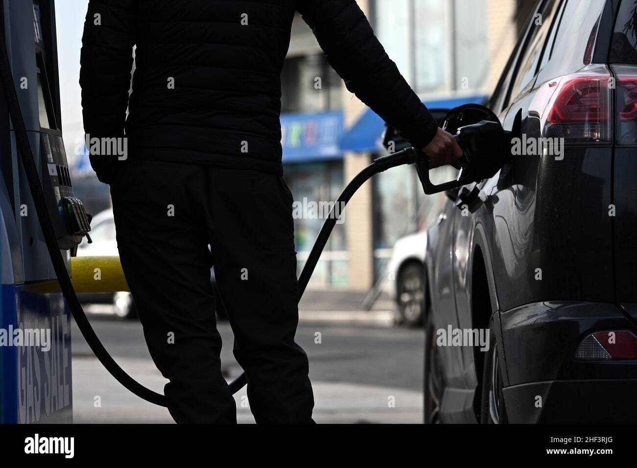 A man pumps gas at a filling station in the New York City borough of