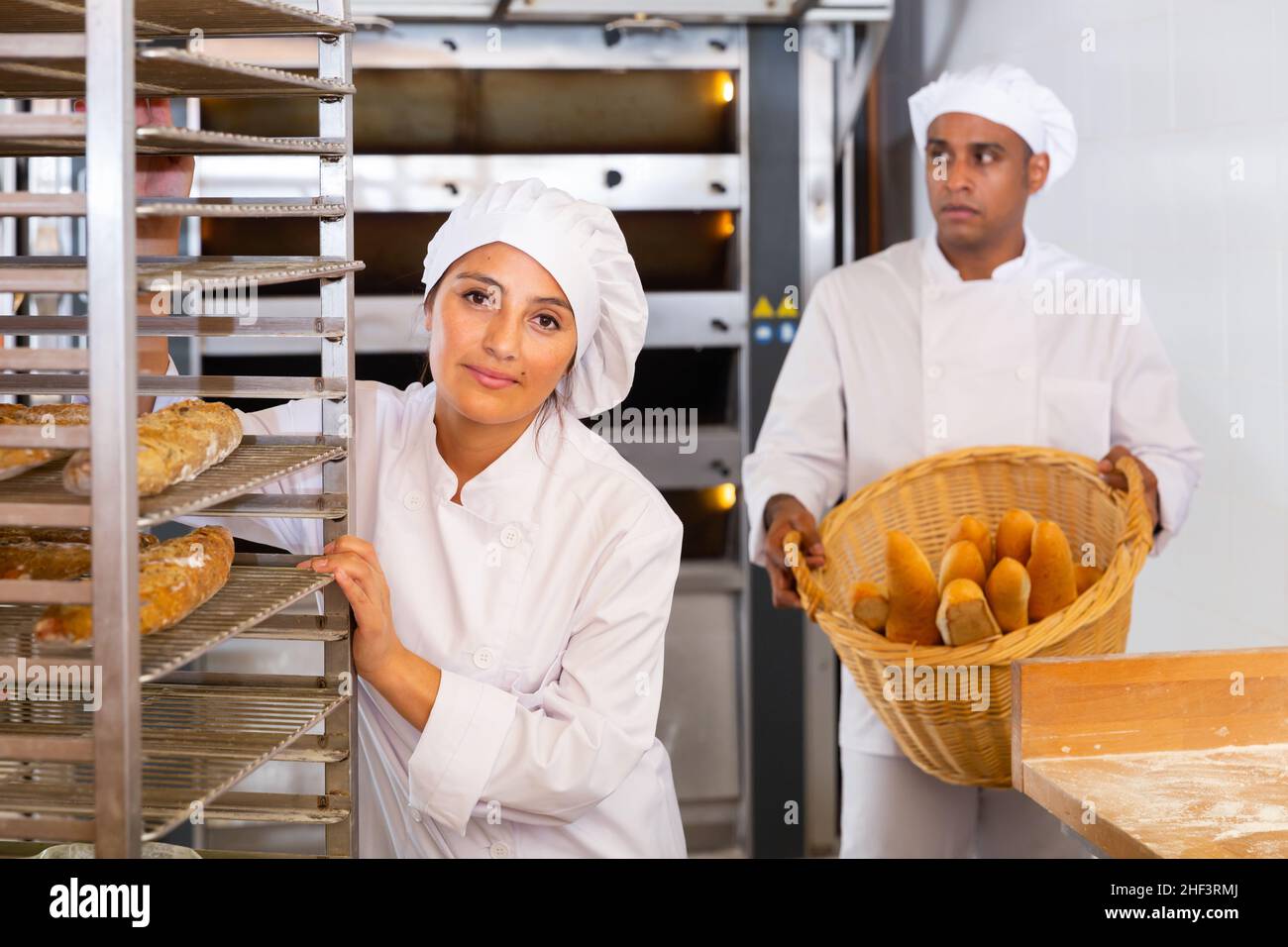 Woman transporting a cart with bread in bakery Stock Photo - Alamy