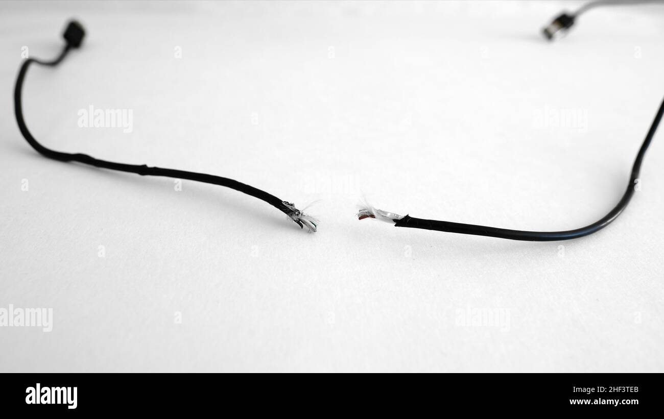Type C phone USB charging cable frayed, broken, torn and separated implicating miscommunication or lack of communication between two parties. Stock Photo