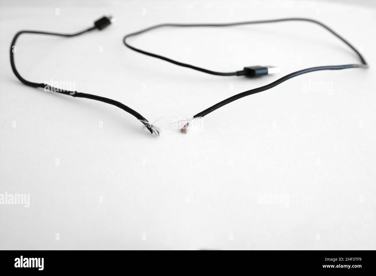 Type C phone USB charging cable frayed, broken, torn and separated implicating miscommunication or lack of communication between two parties. Stock Photo