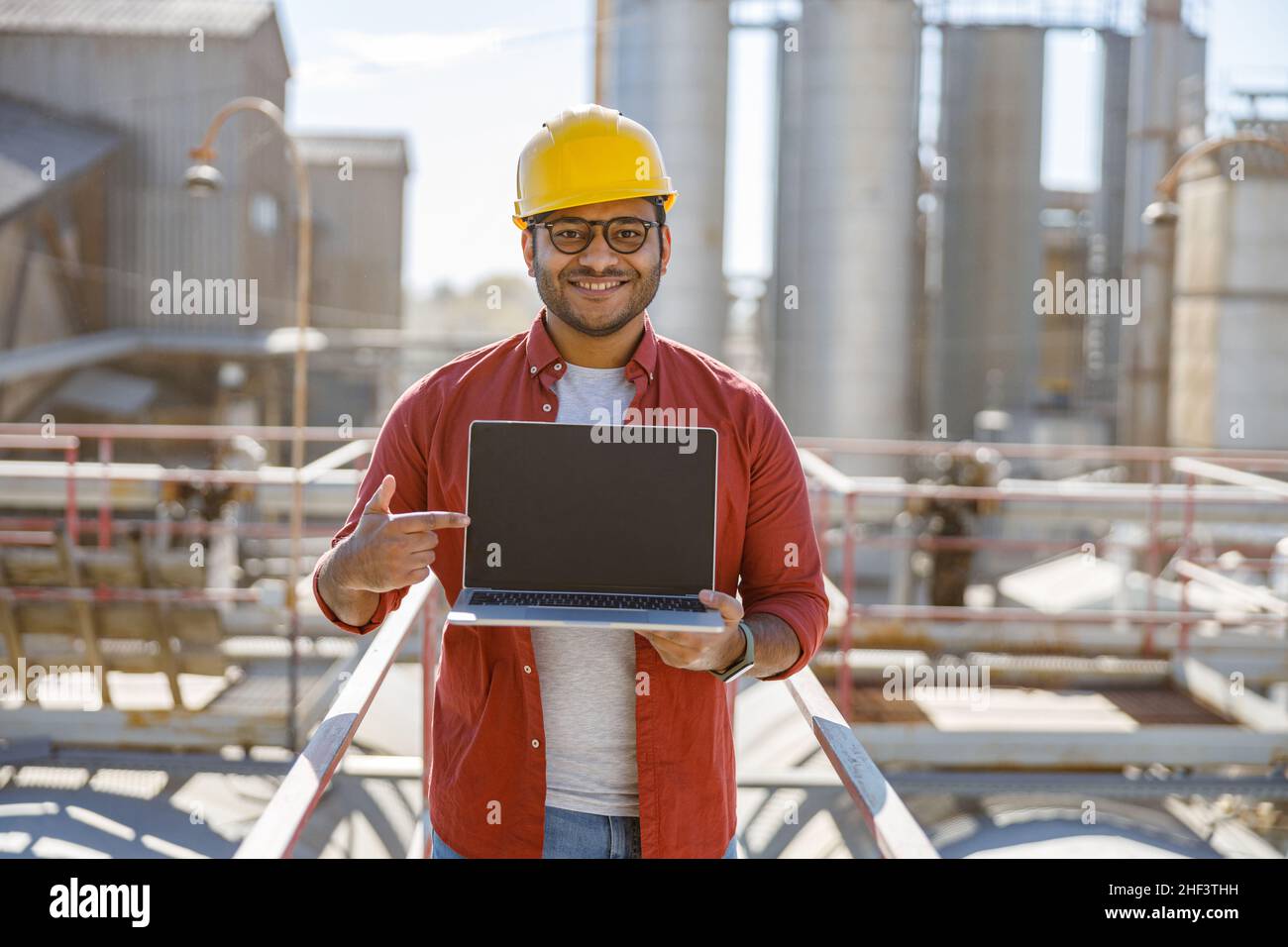 Multiethnic engineer working with laptop at plant Stock Photo