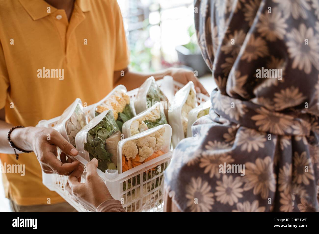 Deliveryman delivers vegetable orders to the customer's house Stock