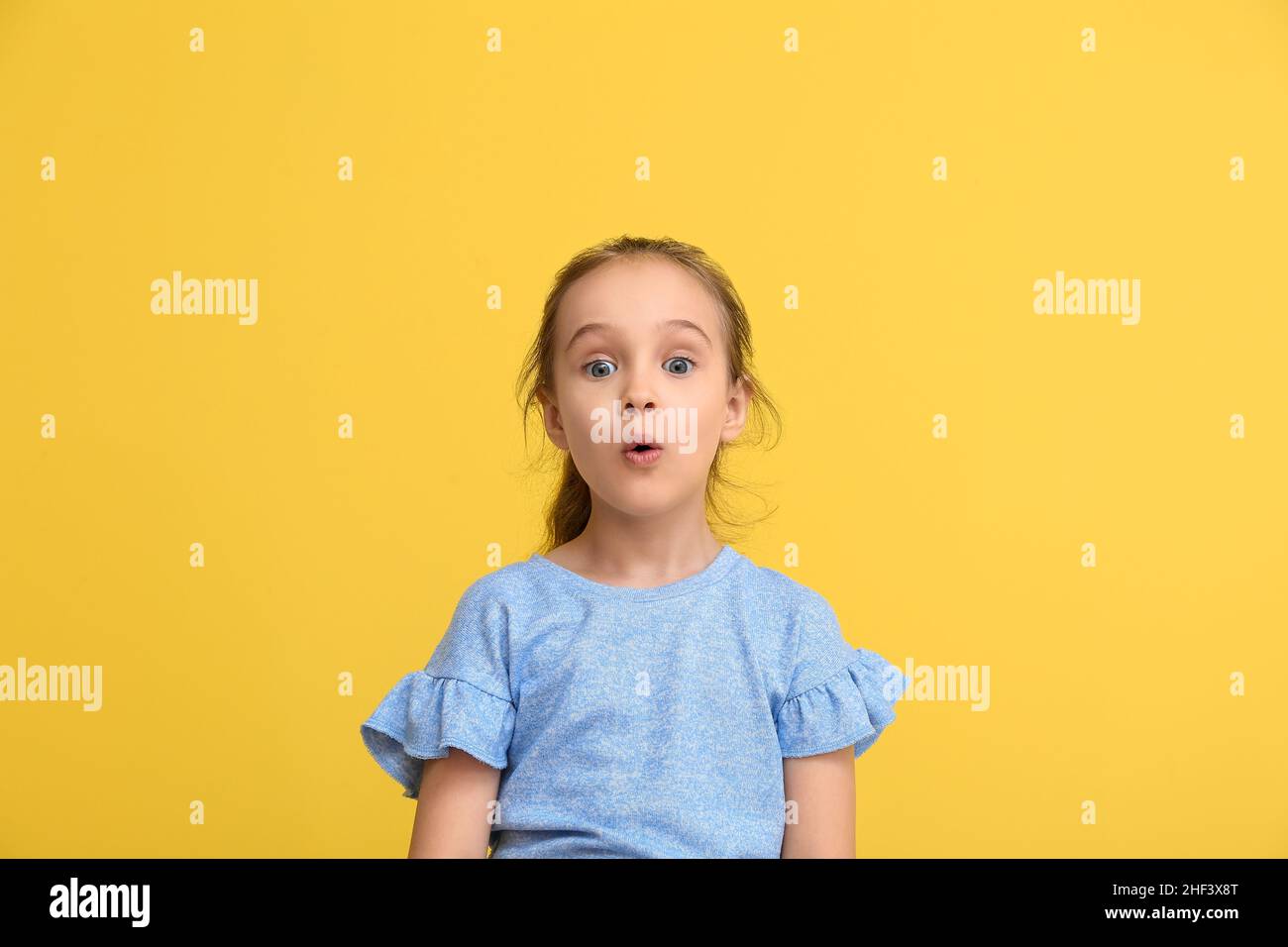 Portrait of surprised little girl on yellow background Stock Photo - Alamy
