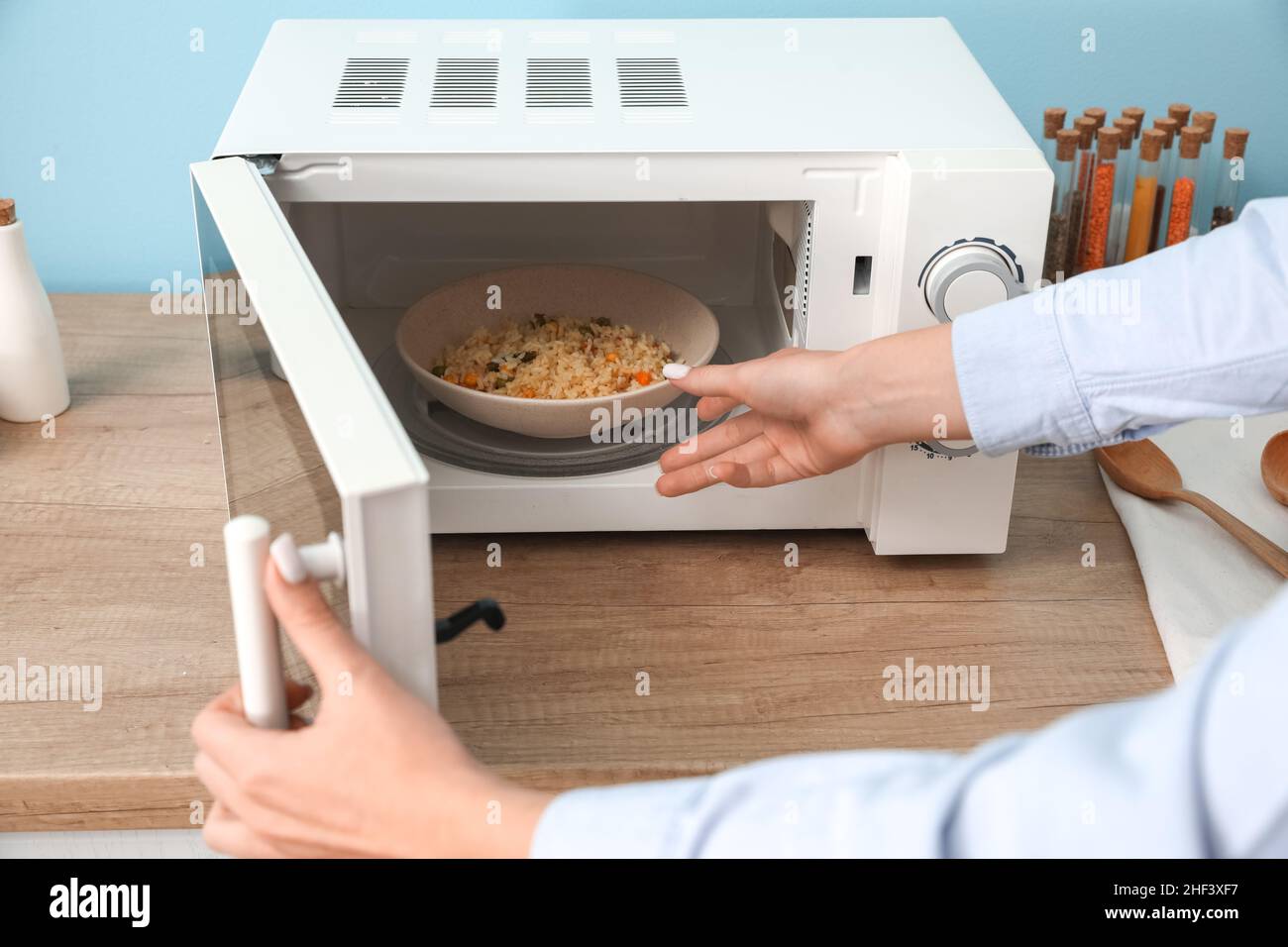 Woman heating food in microwave oven Stock Photo Alamy
