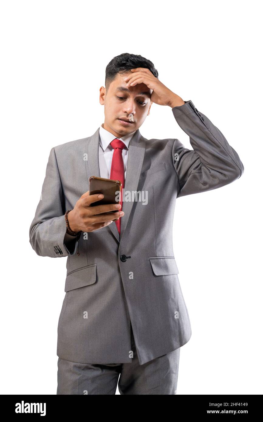 depressed businessman holding his forehead while using his mobile phone Stock Photo