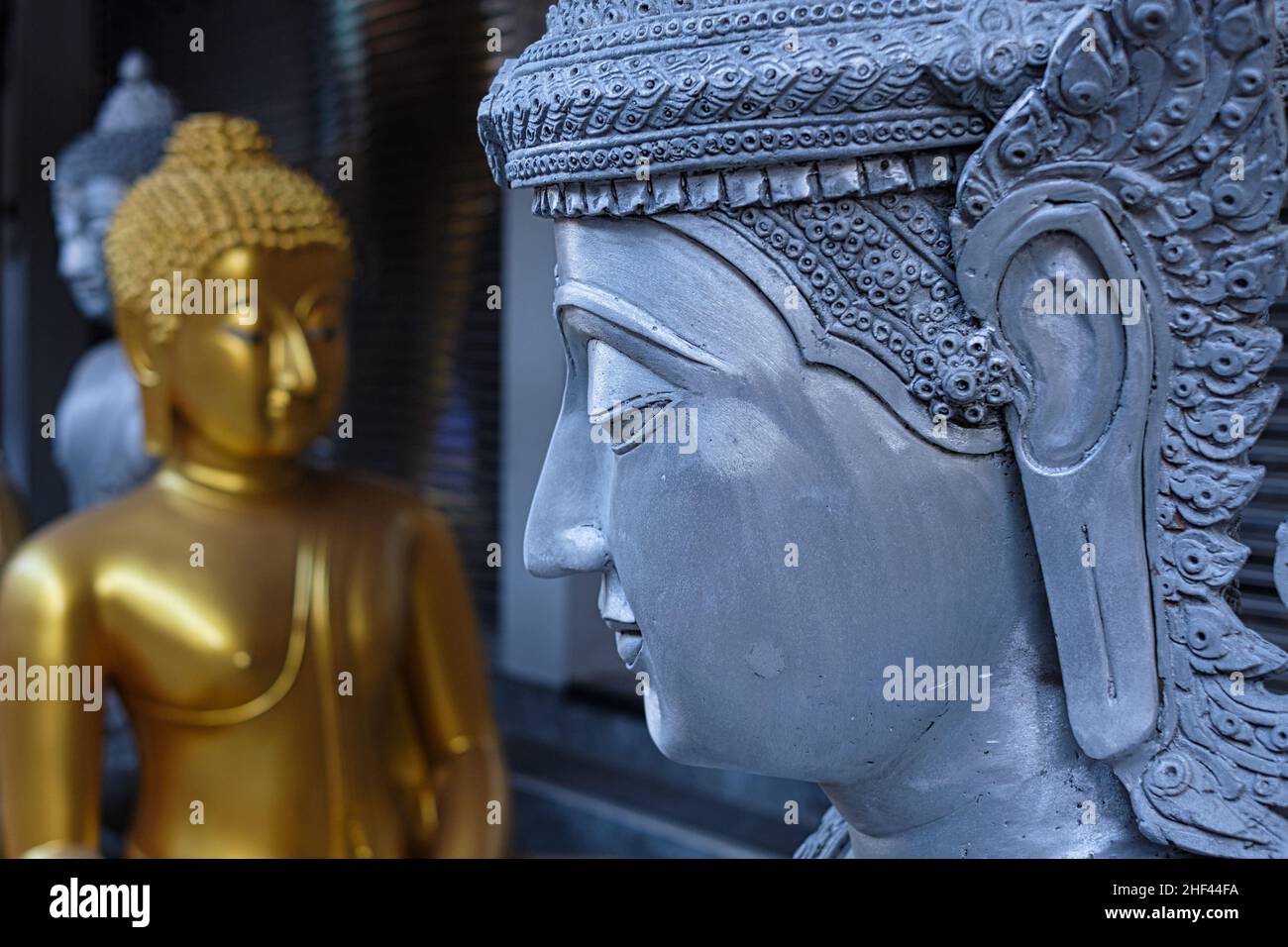 Buddha statues stand outside a shop for Buddhist ritual objects in Bamrung Muang Road, Bangkok
