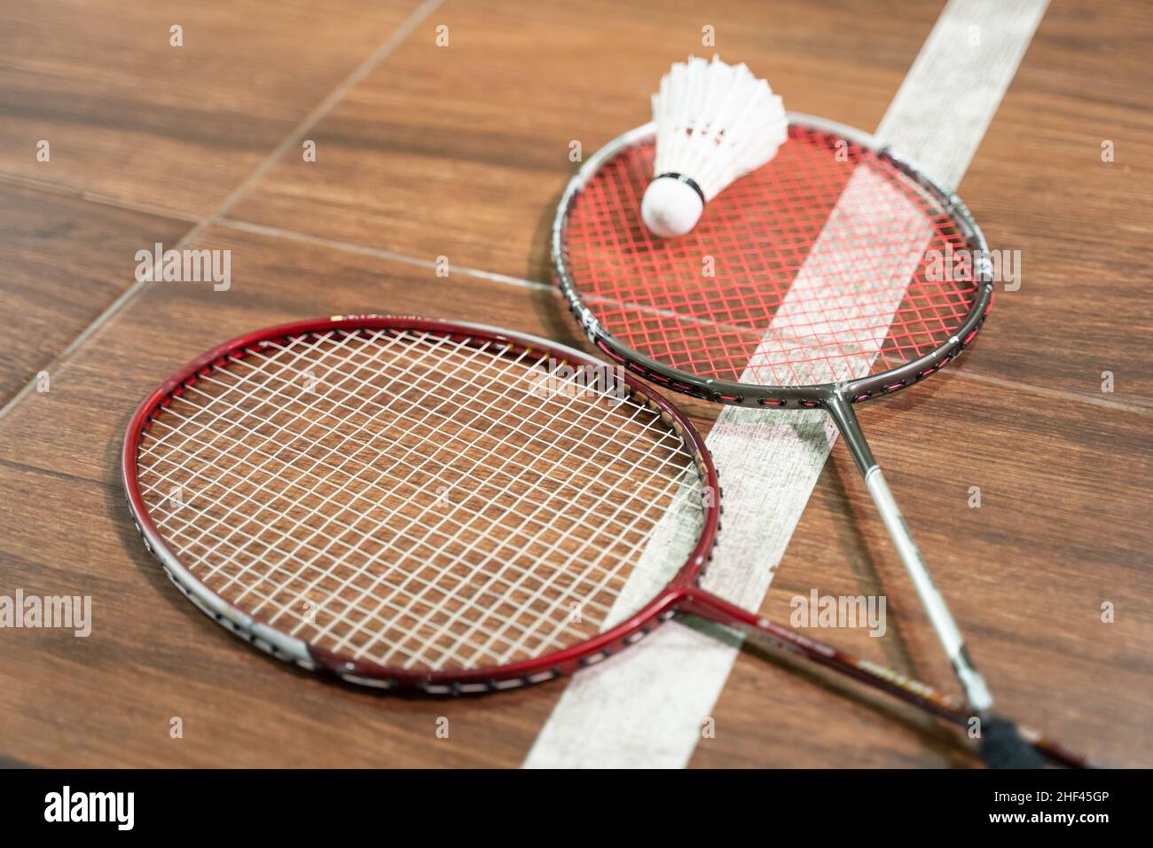 Two rackets and shuttlecock lying on badminton court Stock Photo - Alamy