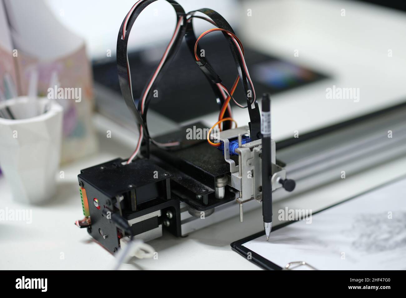 3d printer draws with a pencil on paper, blurry Stock Photo
