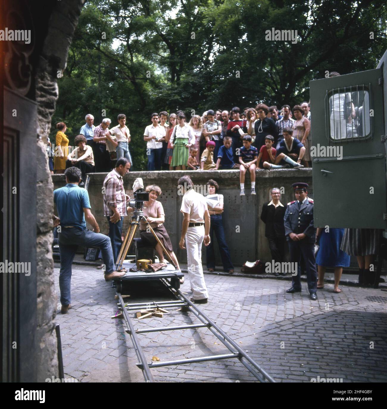 Romanian film director Letitia Popa & team during the shooting of the movie 'Cine mã strigã', 1979. Crowd watching the scene. Stock Photo
