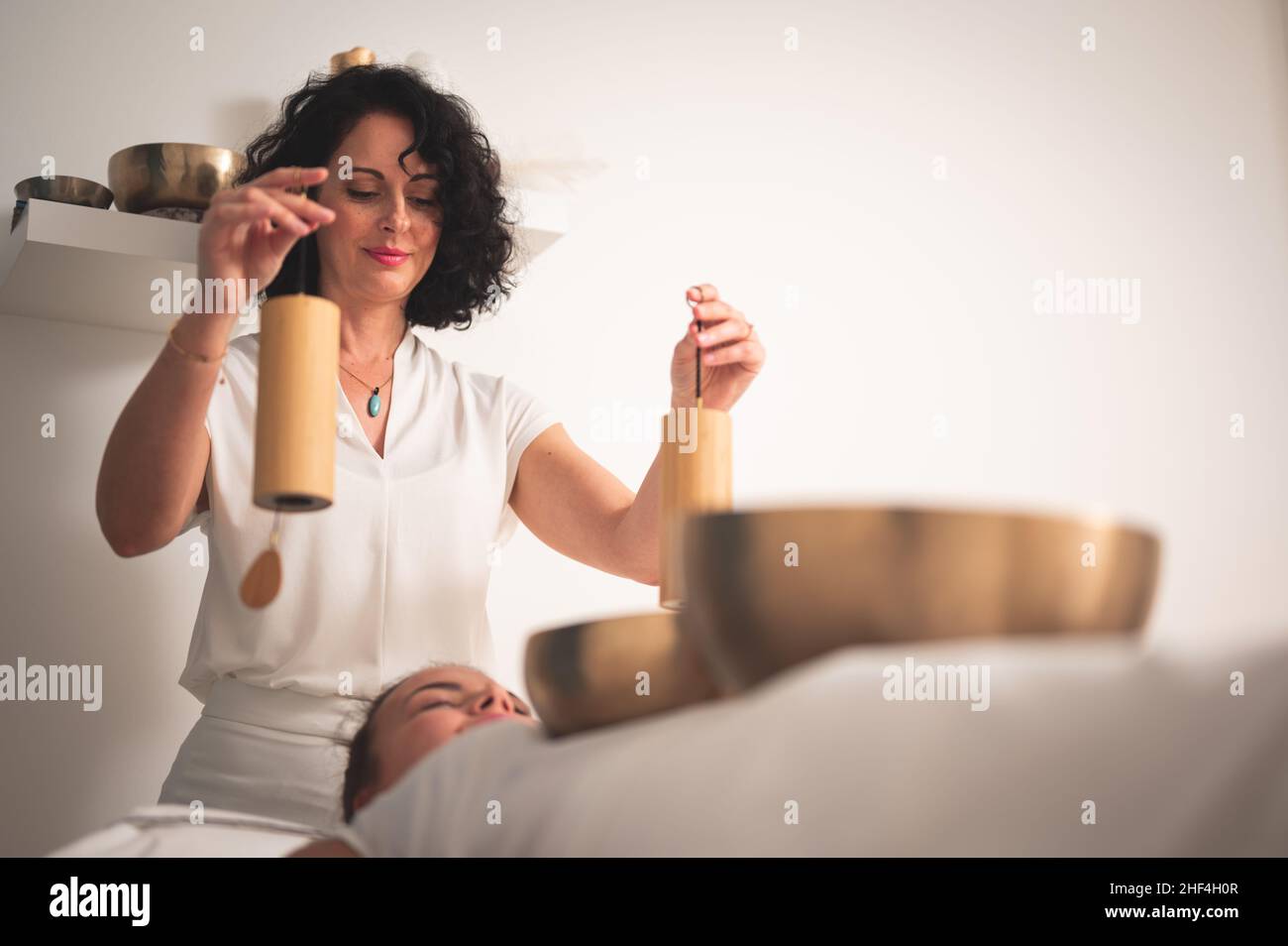 Caucasian female therapist holding Koshi chime musical instrument over