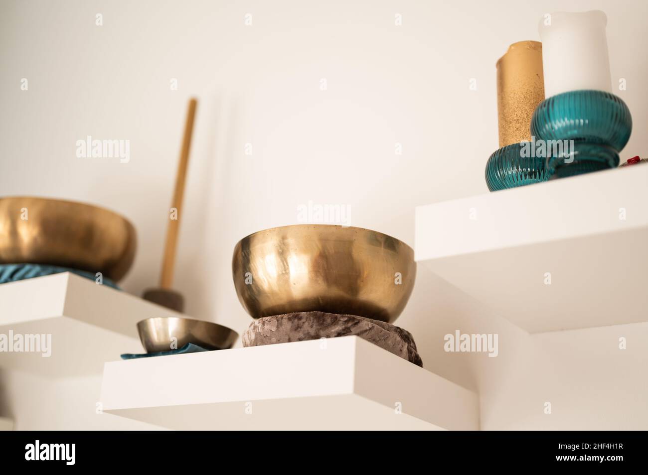 Tools for sound healing therapy singing bowls and stick on white wall