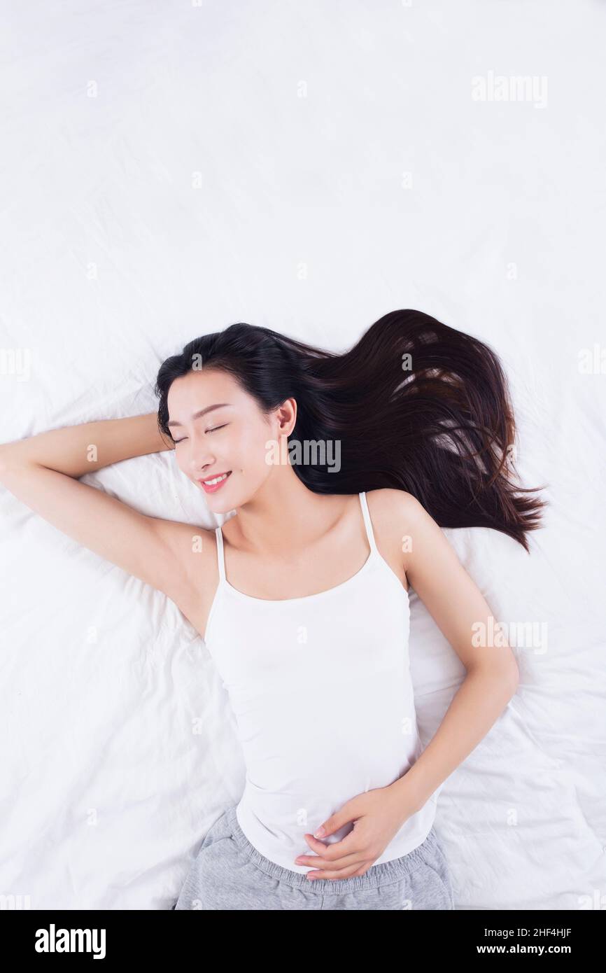 Young woman lying in bed Stock Photo Alamy