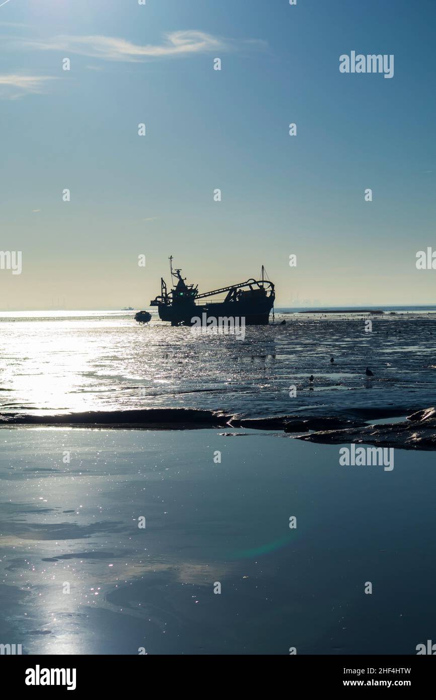 Cockle Boat Lies on Mudflats as Tide Recedes at Old Leigh in Southend West Electoral Constituency on a Bright January Morning Stock Photo