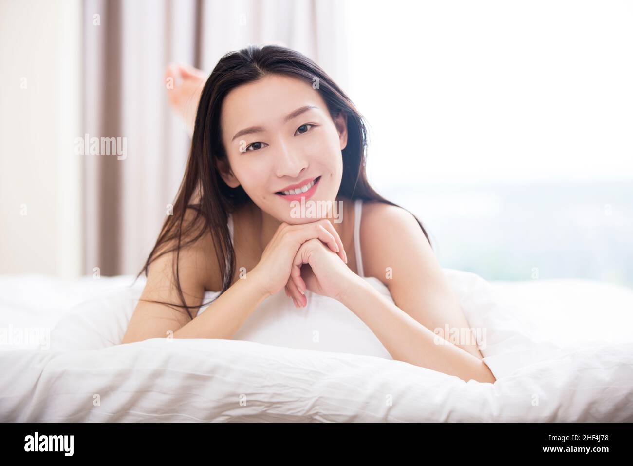 Young woman lying in bed Stock Photo