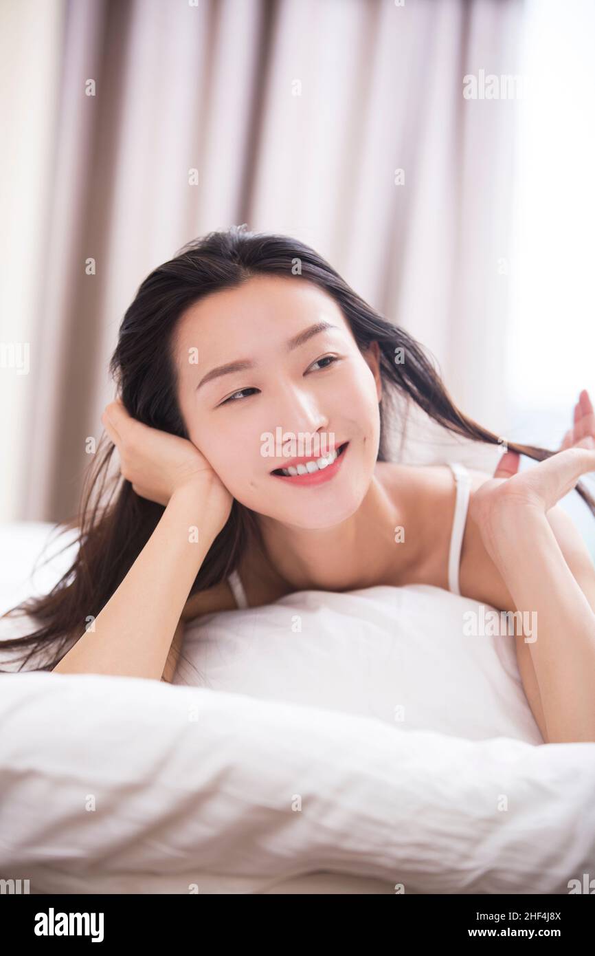 Young woman lying in bed Stock Photo