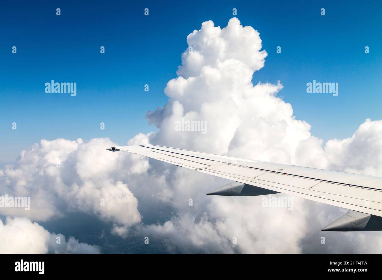 Wing of an airplane flying above the clouds Stock Photo - Alamy