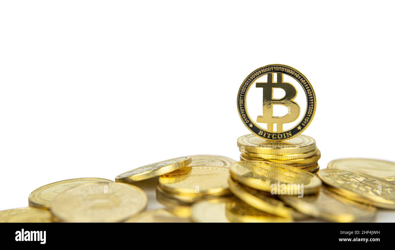 Bitcoin cryptocurrency standing on pile of gold crypto coins isolated on white background with copy space. Stock Photo