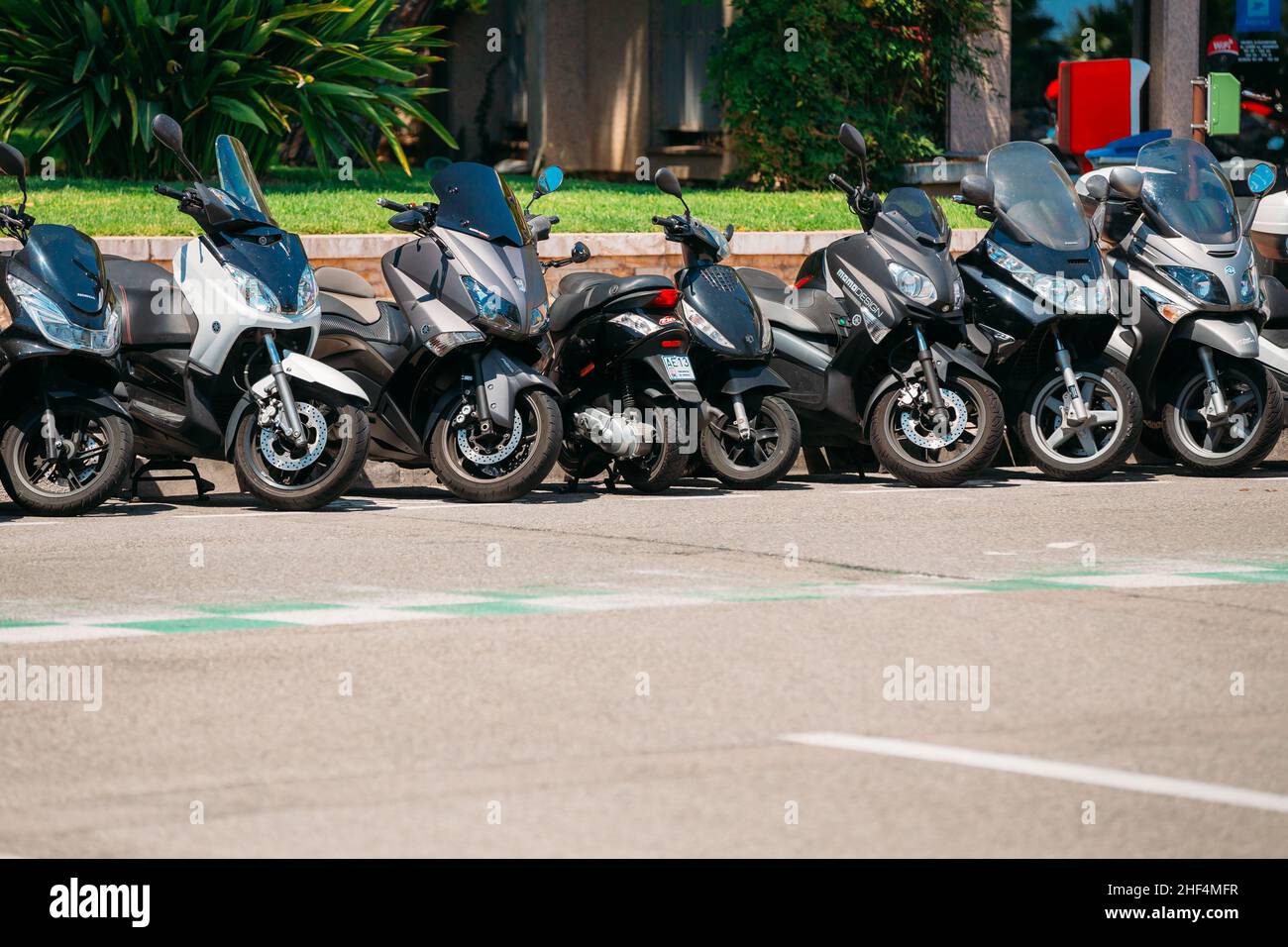 Motorbike, motorcycle scooters parked in row in city street Stock Photo