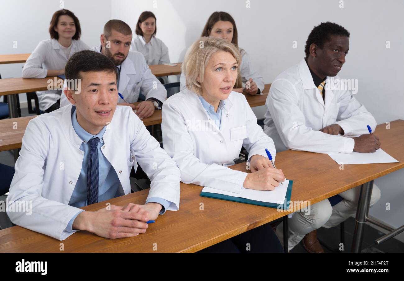 People in white coats in boardroom Stock Photo