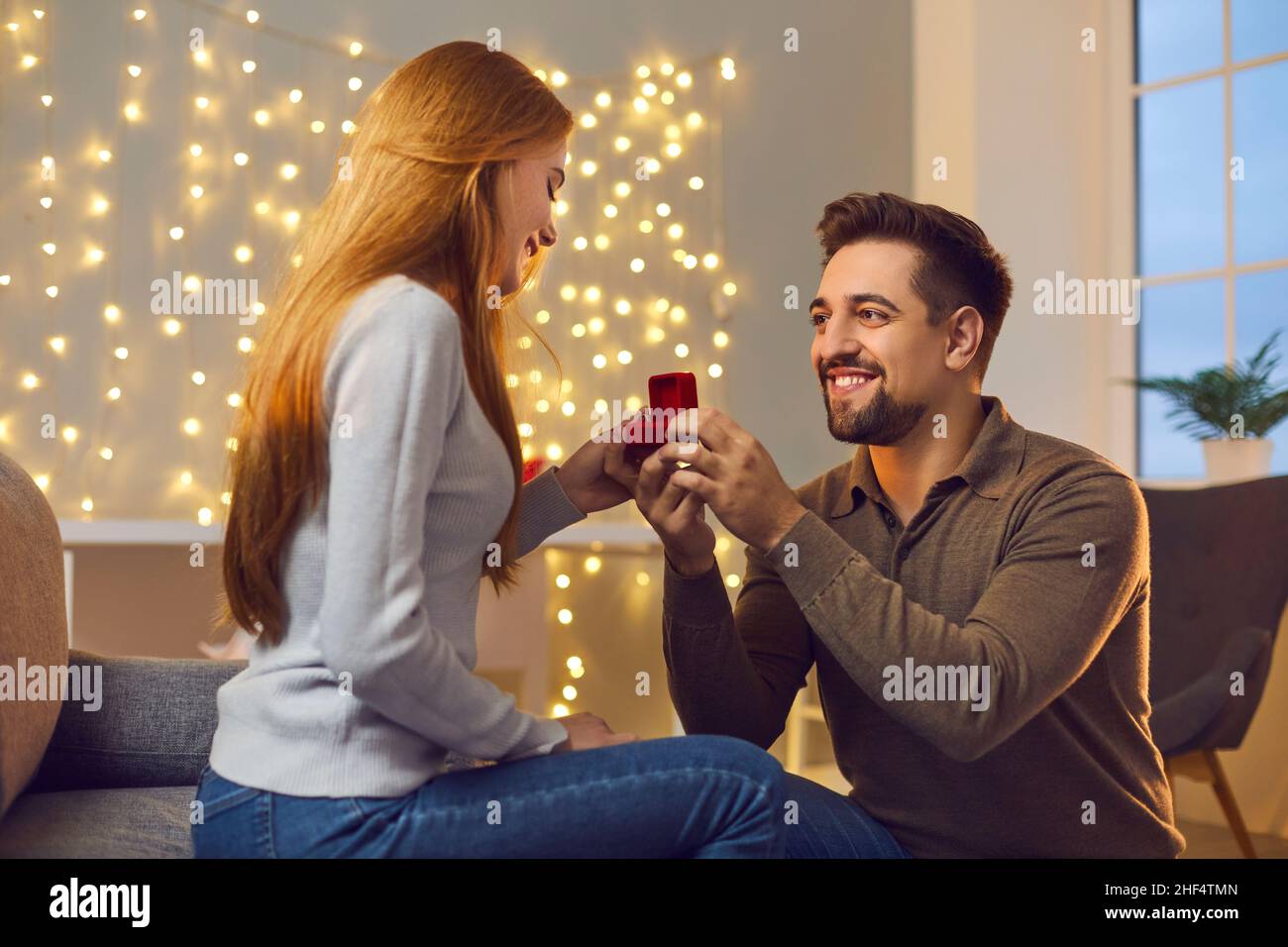 Happy young man in love proposing to his girlfriend and giving her a beautiful ring Stock Photo