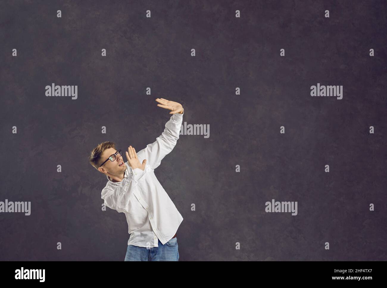 Scared man doing protective stop gesture standing isolated on copy space background Stock Photo