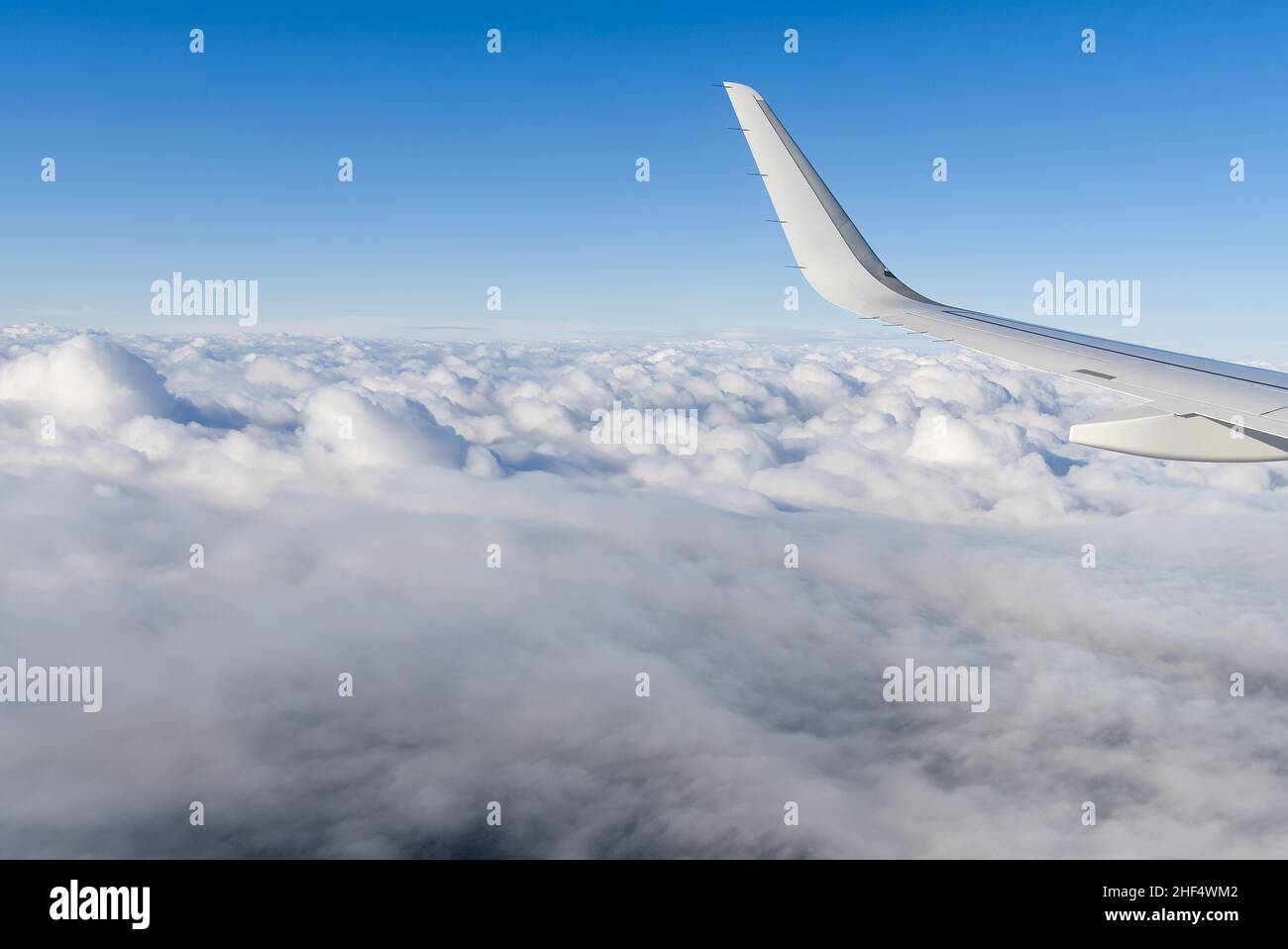 View of airplane white wing flying in blue sky over clouds Stock Photo ...