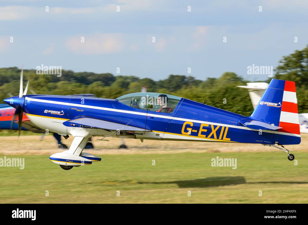 Chris Burkett at the controls of a Extra EA 300 aerobatic plane G-EXIL landing at the Little Gransden Children in Need airshow. Grass runway Stock Photo