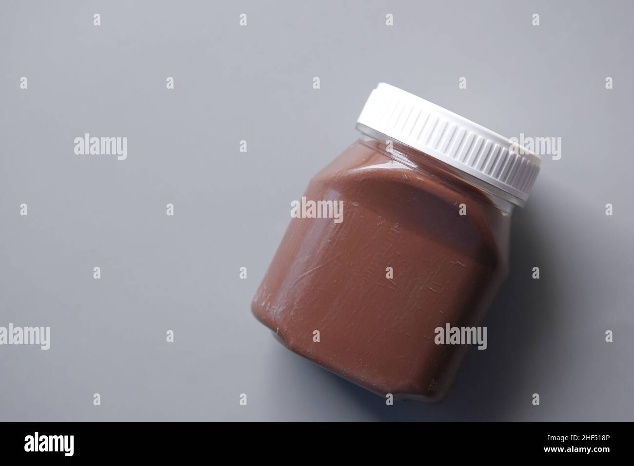 Chocolate Hazelnut cream in a container on black background  Stock Photo