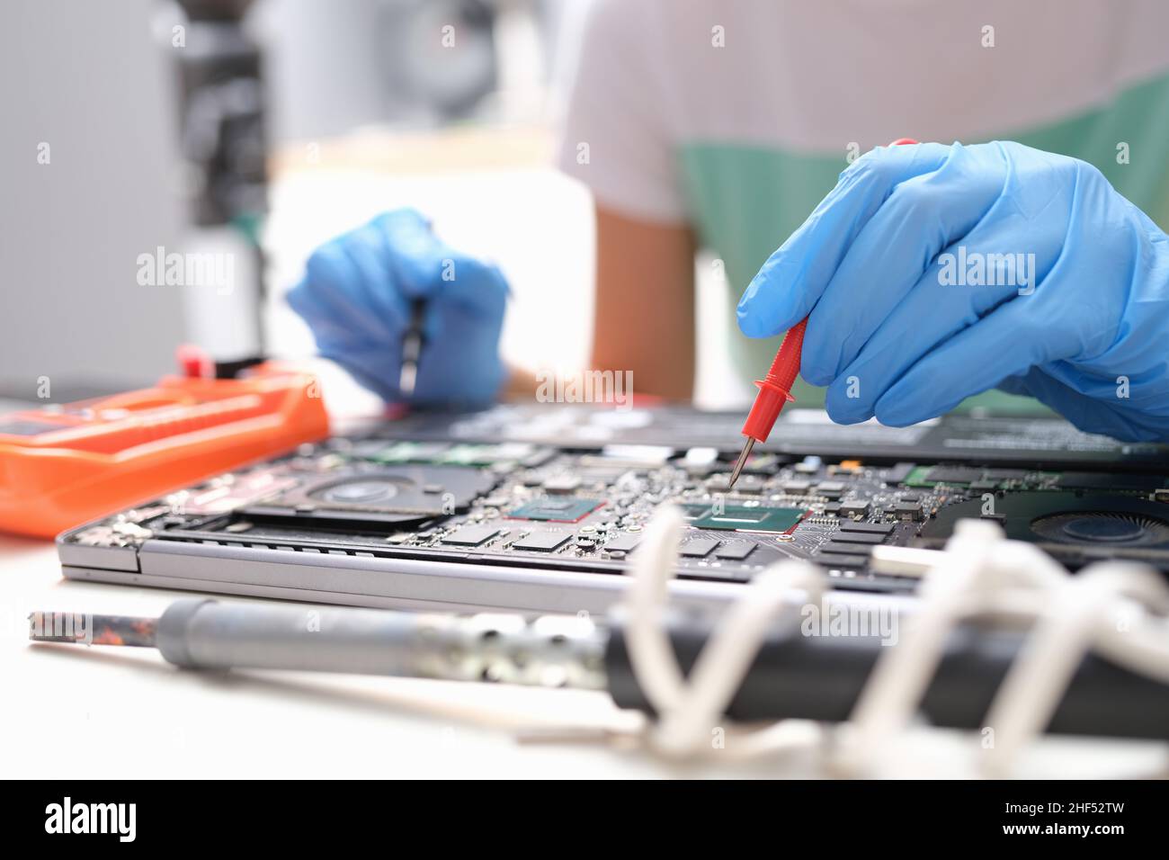Repairman hands hold screwdrivers over laptop processor Stock Photo