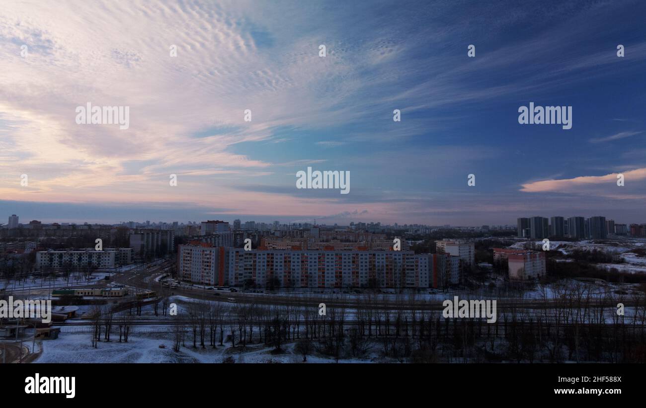 Flying over a snowy park. The city is visible on the horizon. Aerial photography. Stock Photo