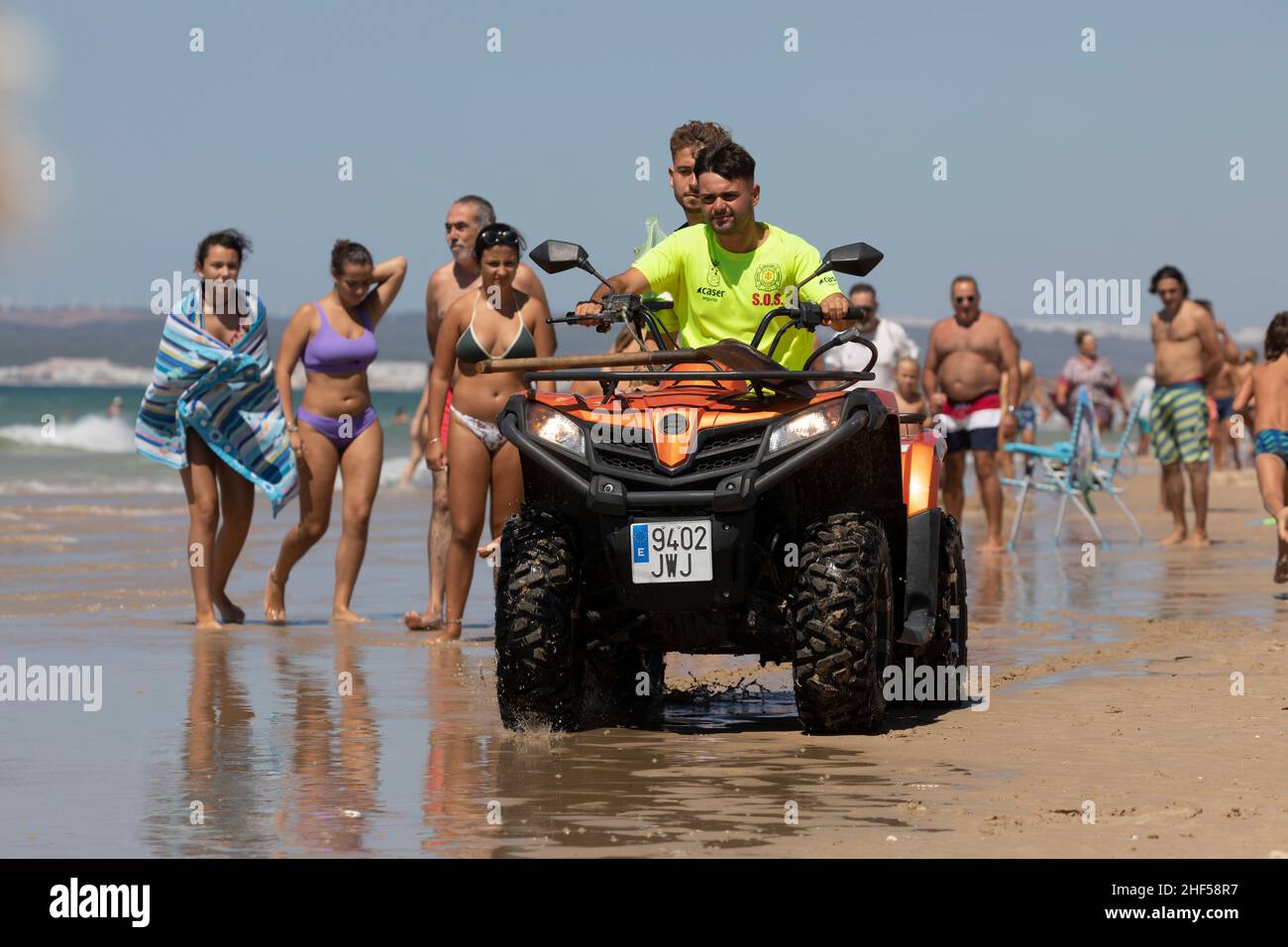 Zahara de los Atunes, Spain - Sept 04, 2021: Two men, lifeguards working for the lifeguard service, ride a quad on the beach, Cadiz province Stock Photo