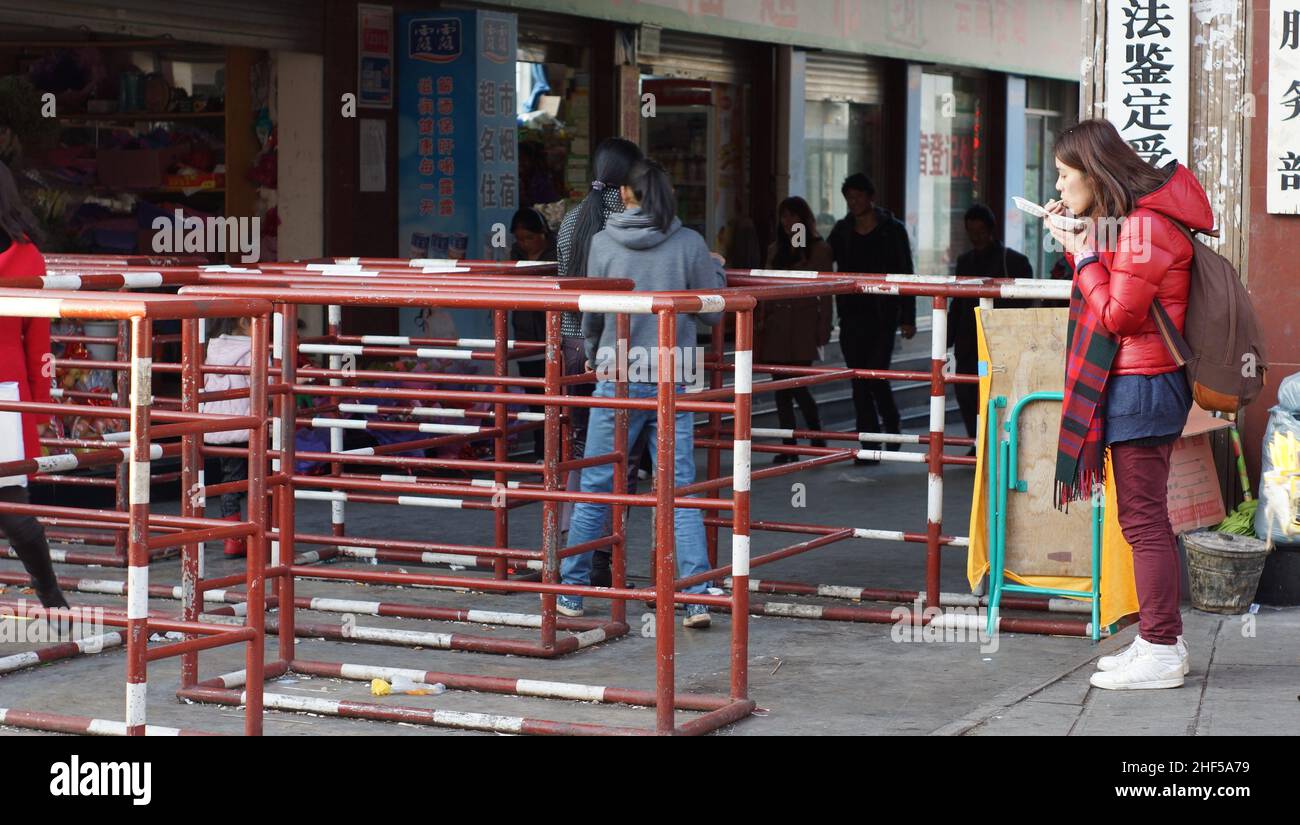 chinese woman eating at the entrance of market in yunnan, lijiang Stock Photo