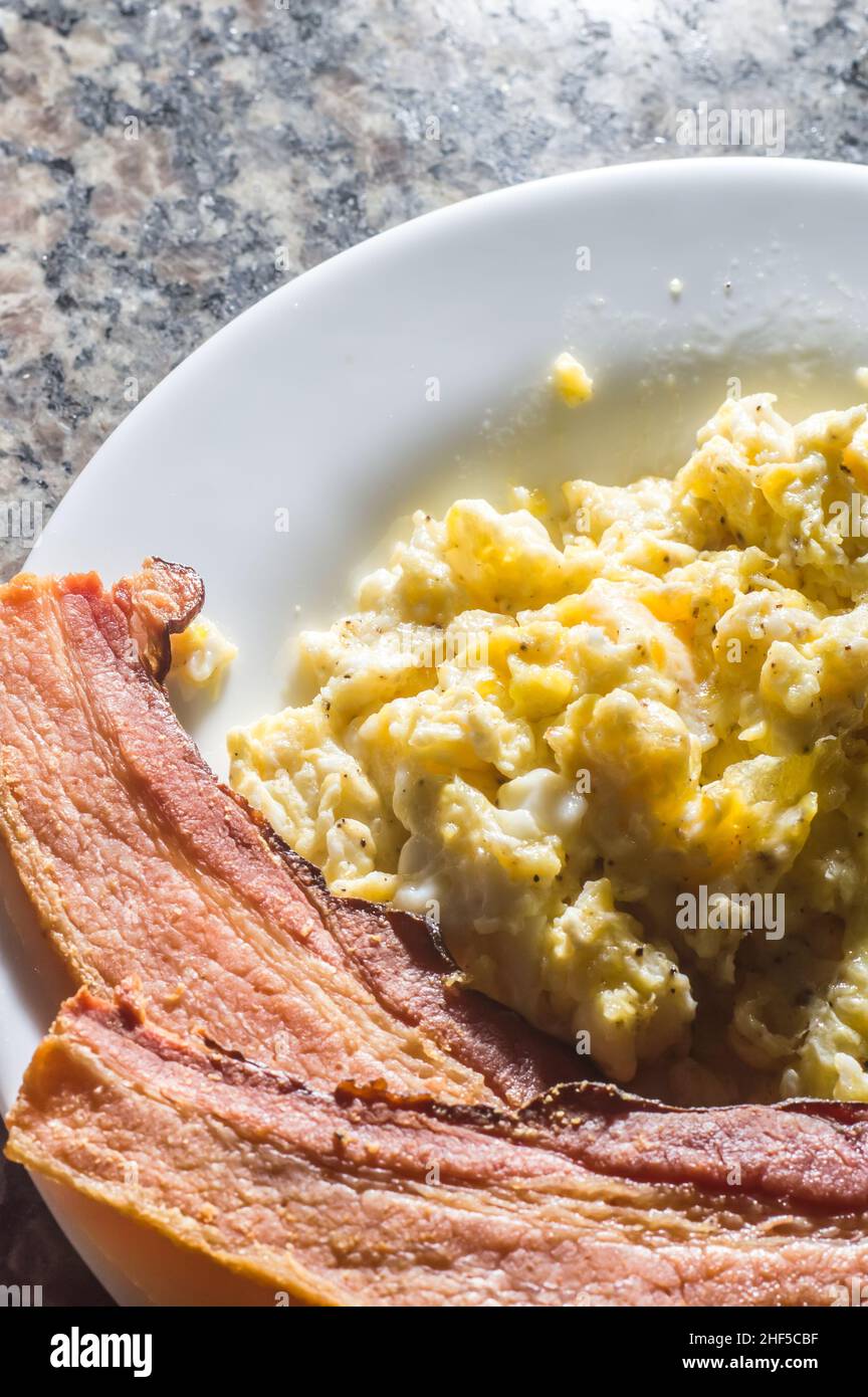 https://c8.alamy.com/comp/2HF5CBF/sliced-bacon-on-a-plate-with-scrambled-eggs-and-a-cup-of-coffee-on-the-side-2HF5CBF.jpg