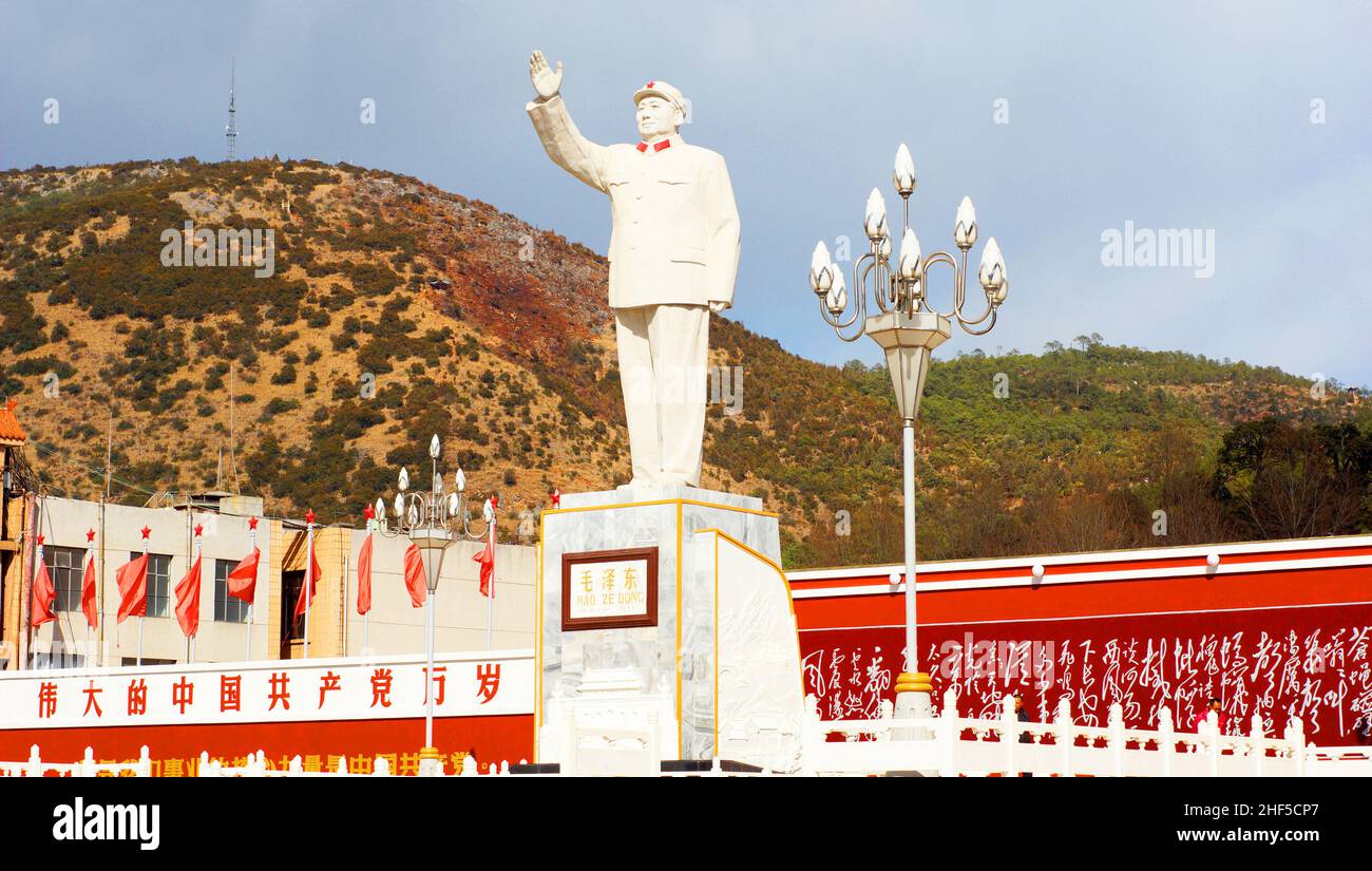 Mao statue,with the slogan on wall: ' Long live the great Communist Party of China'  in Lijiang on Feb 18 2012.  Mao, a statesman Stock Photo