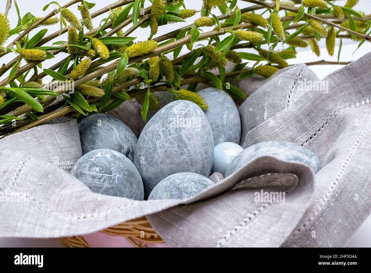 Marble-colored Easter eggs in a linen napkin with willow branches. Easter background. Horizontal photo. Stock Photo