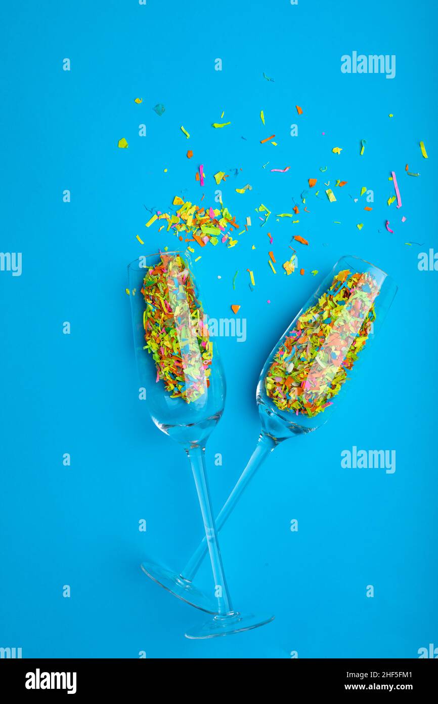 Overhead view of colorful confetti and champagne flutes isolated on