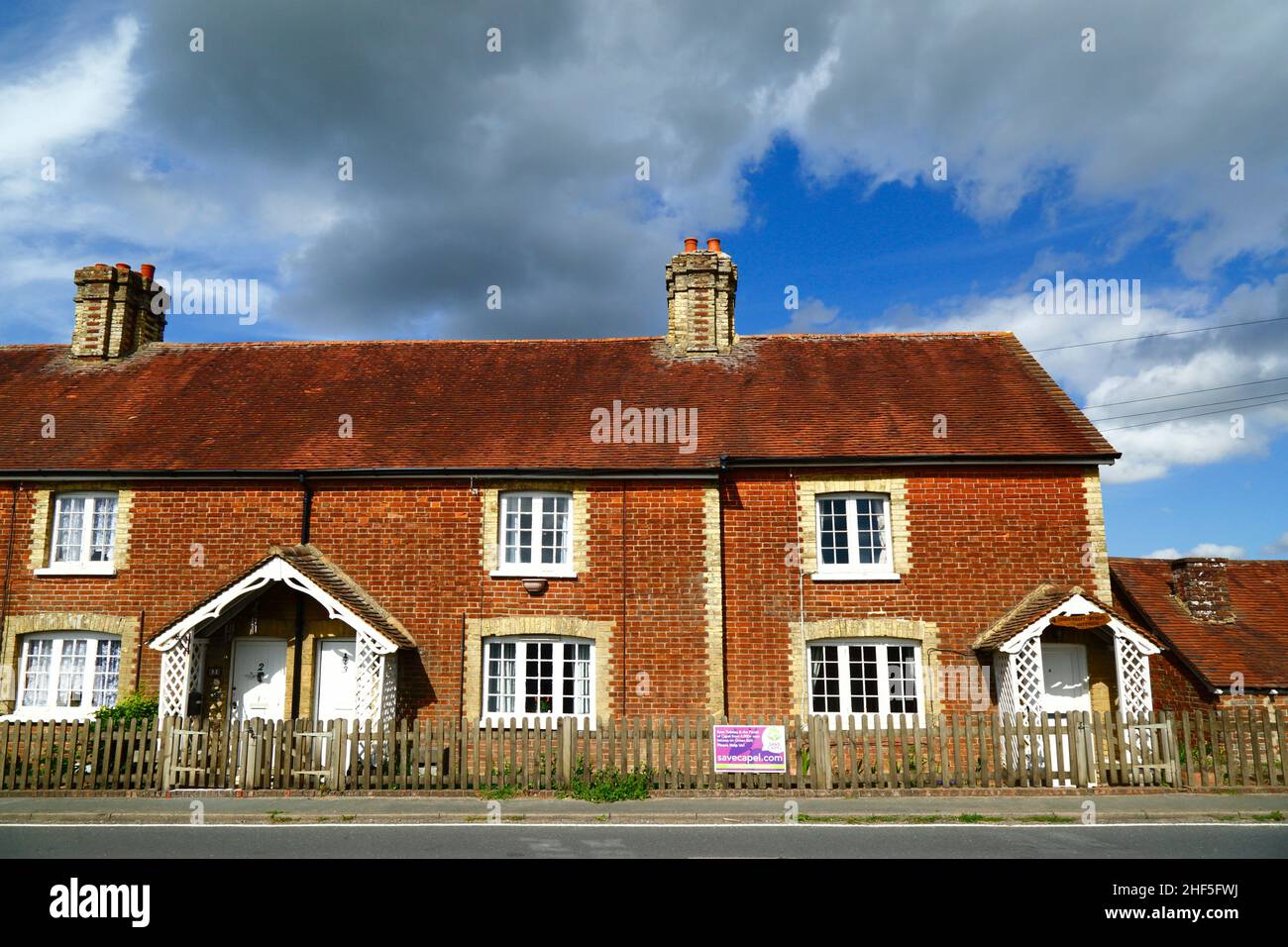Row of typical brick cottages next to B2017 Five Oak Green Road in Tudeley village, Kent, England Stock Photo