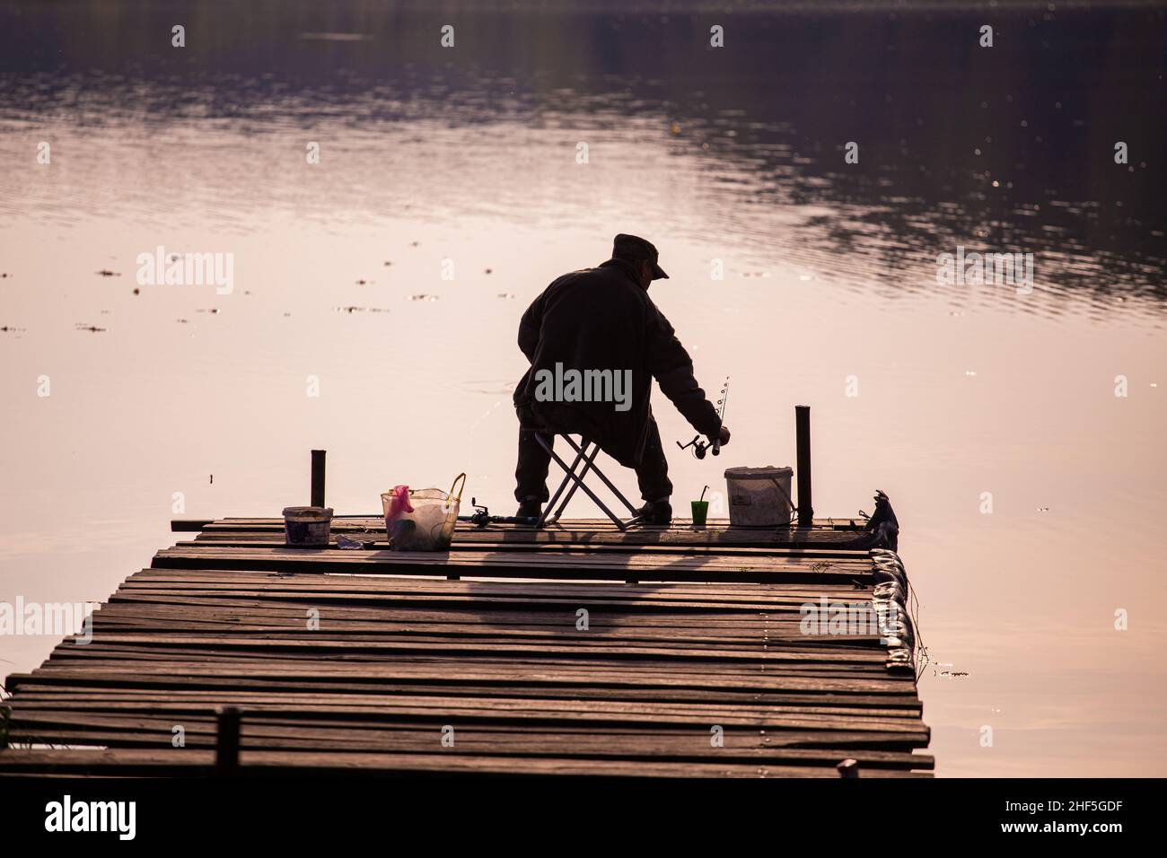 Man sitting fishing from behind hi-res stock photography and images - Alamy
