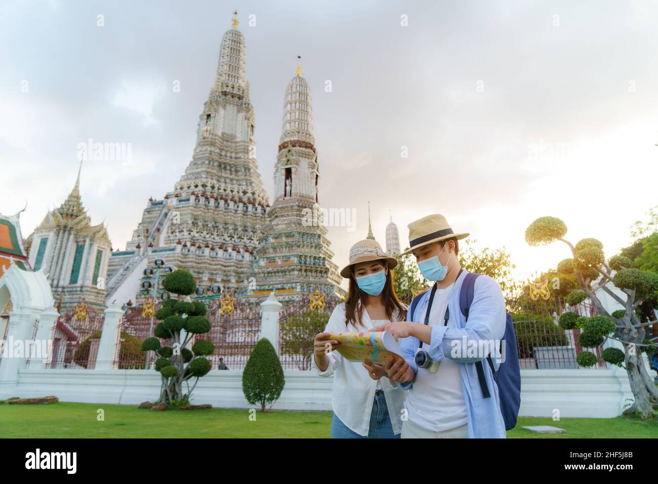 Asian couple happy tourists to travel on they holidays and holding in Wat Arun Temple in Bangkok, Thailand Stock Photo