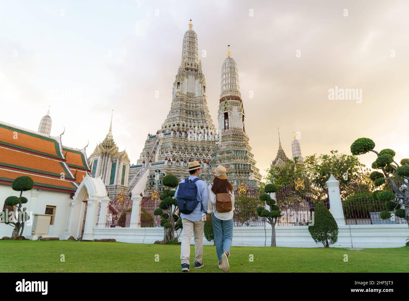 Asian couple happy tourists to travel on they holidays and holding in Wat Arun Temple in Bangkok, Thailand Stock Photo