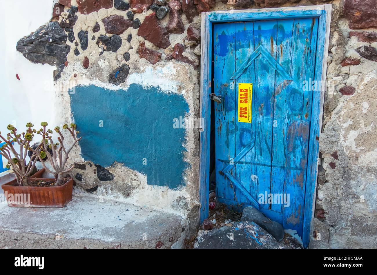 Marode Immobilie mit typische blauer Holztür wird auf einer griechischen Insel zum Verkauf angeboten Stock Photo