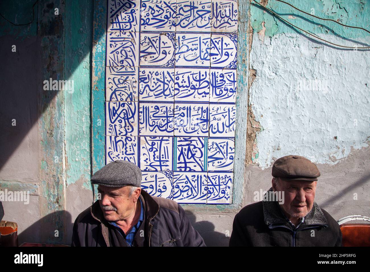 Kutahya,Turkey - 02-03-2017:Wall covered with historic tiles, two old men waiting Stock Photo
