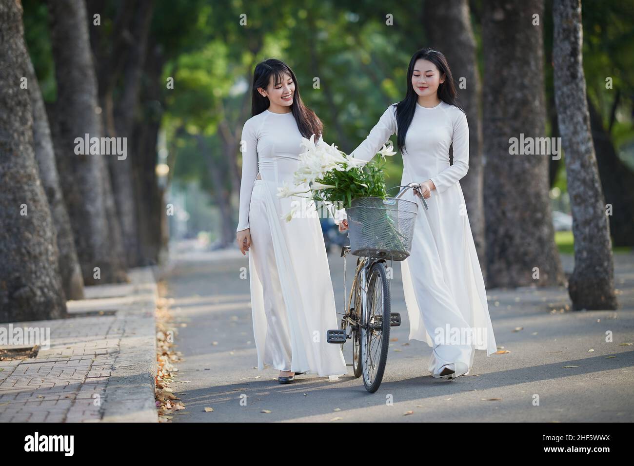 Ho Chi Minh City, Vietnam: Portrait women in white ao dai Vietnam, The Ao dai ( long-dress Vietnamese) is traditional costume of Vietnamese woman Stock Photo