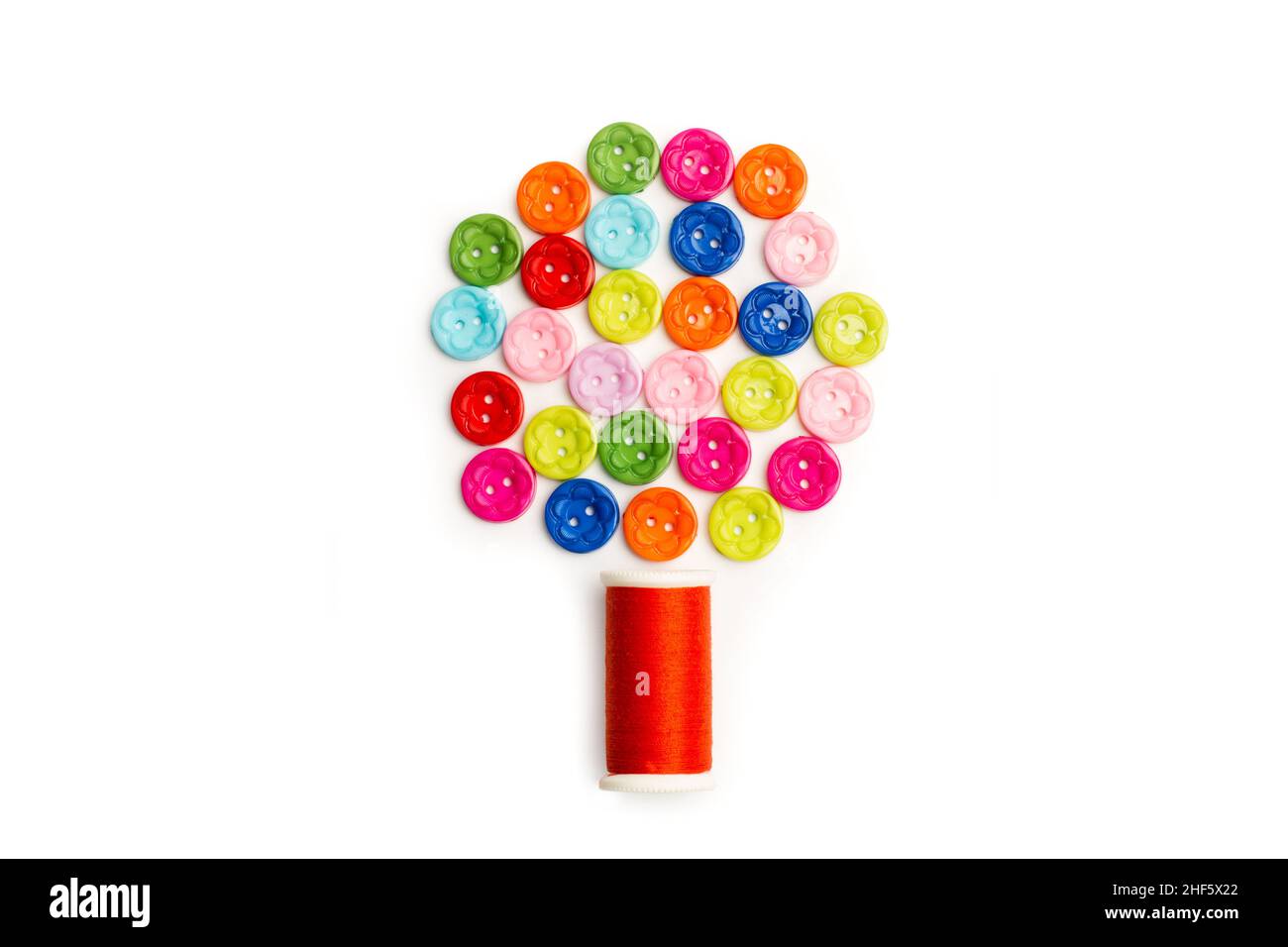 Colored buttons and a thread spool in a tree shape on a white background Stock Photo