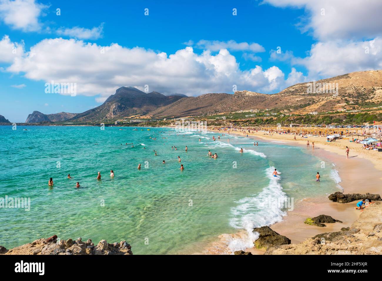 Holidaymakers swimming and sunbathing on picturesque Falassarna beach. Crete, Greece Stock Photo
